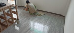 anh em thợ đang xử lý nẹp ốp tường cho sàn